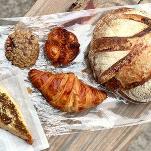 Feta-Za&apos;tar Scone ($4.90), Kouign-Amann ($5.20), Croissant ($4.70), Cherry Oat Cookie ($3), 1/2 Fig-Walnut Loaf ($6.50), 1/2 Sourdough ($6)