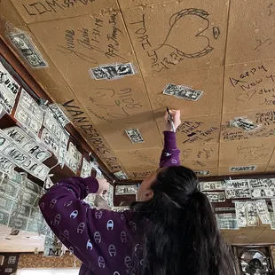 a woman drawing on the ceiling