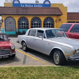two classic cars parked in front of a restaurant