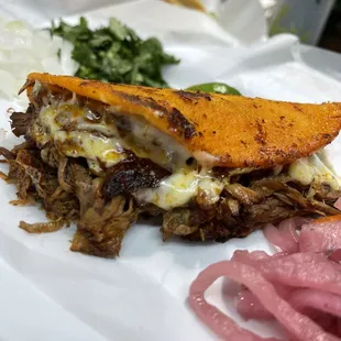 a pulled pork sandwich on a white plate