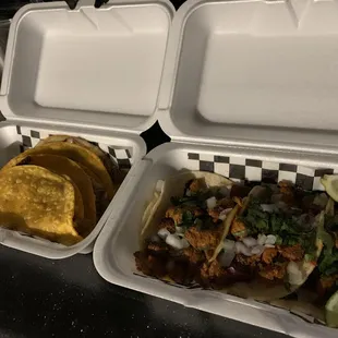 two trays of tacos and a lime wedge