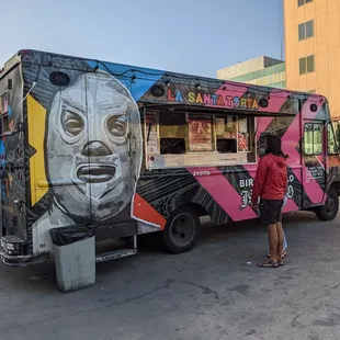 a woman standing in front of a food truck