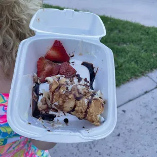 a child holding a container of food