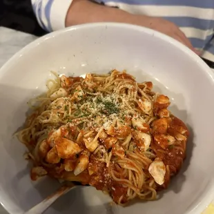 a bowl of pasta with shrimp and parmesan cheese