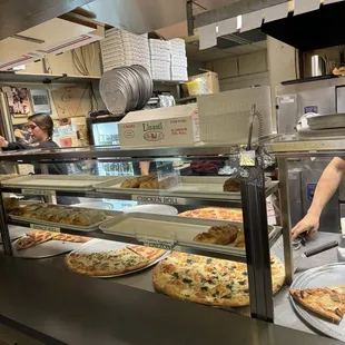 a man preparing pizzas in a kitchen