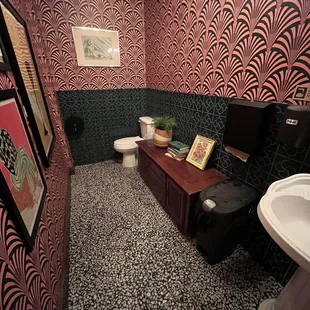 a bathroom with black and pink wallpaper