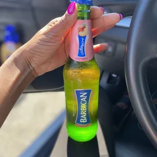 a woman holding a bottle of la shish kabob