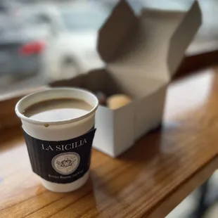 Italian specialty cookies in a box, alongside small cup of drip coffee at bar along front window of La Sicilia.