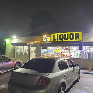 a car parked in front of a liquor shop