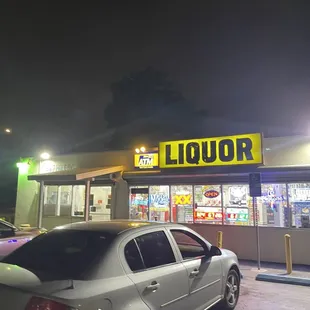 a car parked in front of a liquor shop