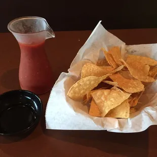 a bowl of chips and a pitcher of salsa