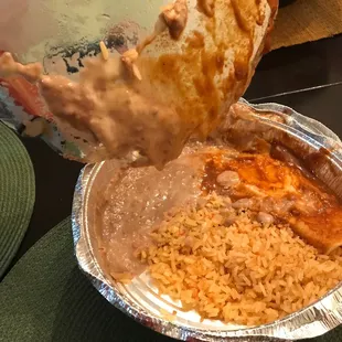 a person dipping a piece of bread into a container of food