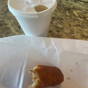 a half eaten donut and a cup of coffee