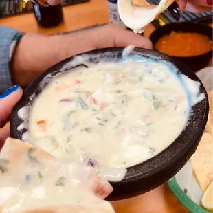 a person dipping a tortilla