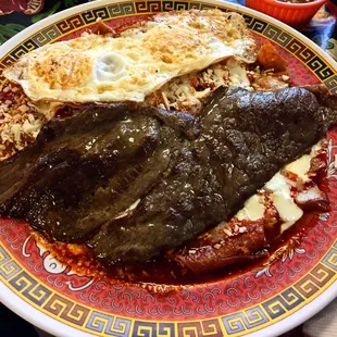 Chilaquiles rojos con huevos, queso y bistec