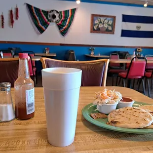 Big cup of Atol de Elote. 3 pupusas with curtido and sauce. Inside restaurant.