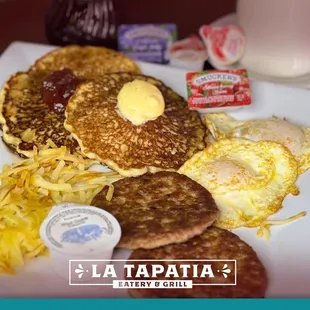 a plate of pancakes, eggs, and hash browns