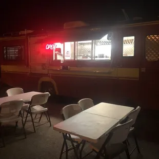 Outdoor seating and the taco truck&apos;s order window.