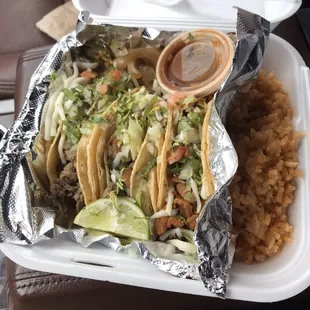 Two asada and one pastor tacos with rice