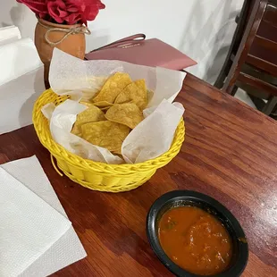 a basket of chips and a bowl of salsa