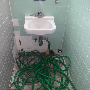 a bathroom with a sink and hoses