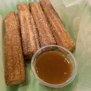 a plate of churrons and a cup of sauce