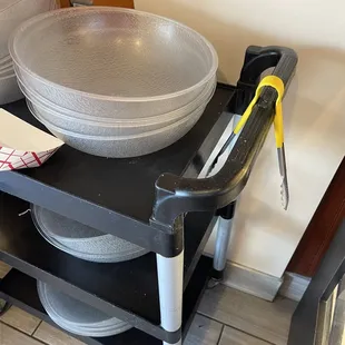 a black cart with plates and utensils on it