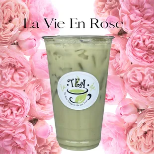 a cup of green tea with pink flowers in the background