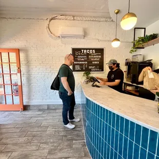 a man standing at a counter in a restaurant
