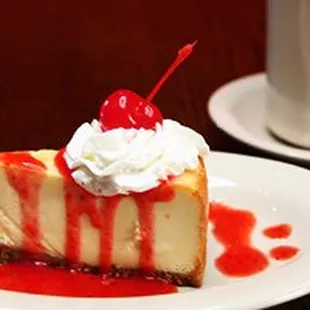 a slice of cheesecake with a cherry on top