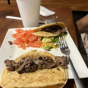 a plate of tacos and a drink