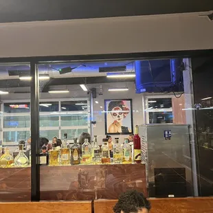 a man sitting on a bench in front of a bar