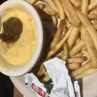 a plate of fries and a bowl of sauce