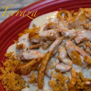Plato Feliz Grilled chicken on bed of rice smothered in cheese dip.
