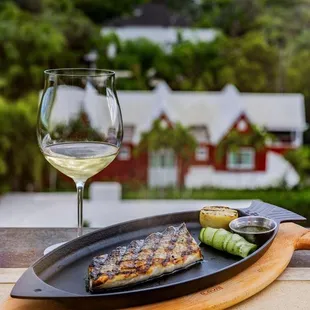 a plate of fish and a glass of wine