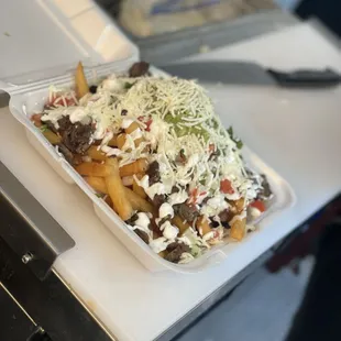 Asada fríes topped with cheese pico sour cream and guacamole