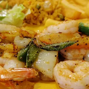 a plate of food with shrimp and french fries