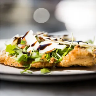Our twist of the traditional cotoletta Milanese -breaded chicken breast, four cheese spread, rich Mediterranean salad, Parmigiano, balsamic