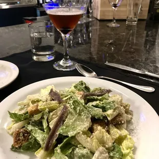 Caesar salad, warm bread, and tasty Manhattan to start the meal.