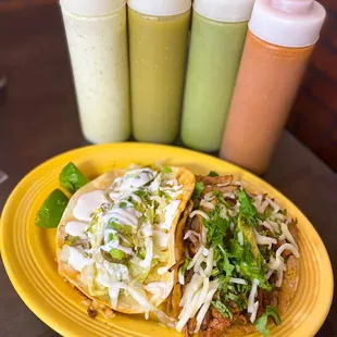 a plate of tacos and condiments