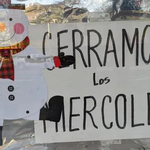 a snowman holding a sign