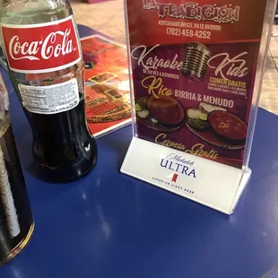 a bottle of coca and a menu