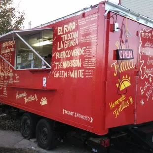 a red food truck parked on the side of the road