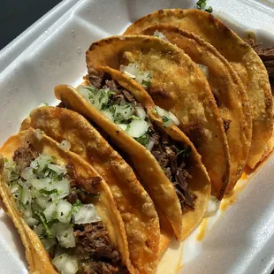 three tacos in a styrofoam container
