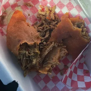 a pulled pork sandwich in a styrofoam container