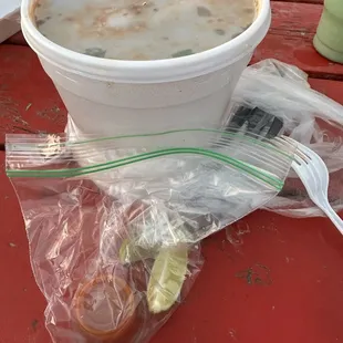 a plastic cup of soup and a fork
