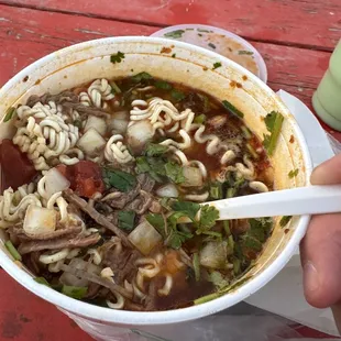 a person holding a bowl of soup