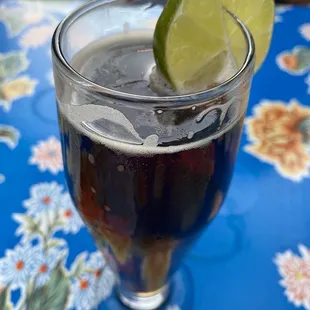 a glass of soda with a lime wedge