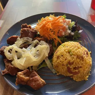 Carne frita y arroz manposteo con ensalada. Cobran $2 extra por este arroz. Y no te lo dicen cuando lo ordenas.