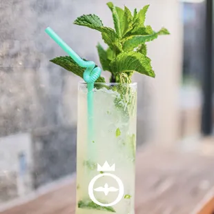 a mojit with mint leaves in a tall glass